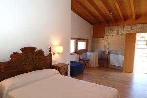a bedroom with a bed and a table and chairs at Casa Rural Vilaboa in Allariz