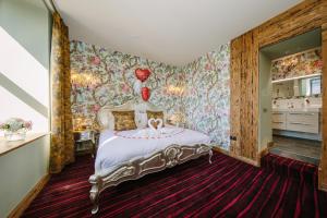 um quarto com uma cama num quarto com papel de parede floral em Grange Boutique Hotel em Grange Over Sands