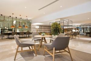 a dining room with chairs and a table in a room at Melia Sevilla in Seville