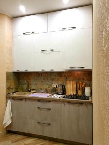 a kitchen with white cabinets and a sink at Tbilisi Apart in Tbilisi City