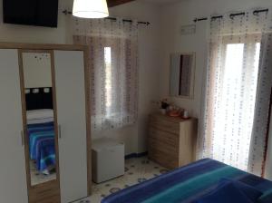 una camera con letto, cassettiera e specchio di Il Canto Dei Venti a Montecorice