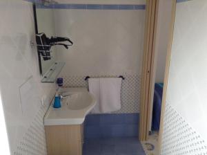 un piccolo bagno con lavandino e specchio di Il Canto Dei Venti a Montecorice
