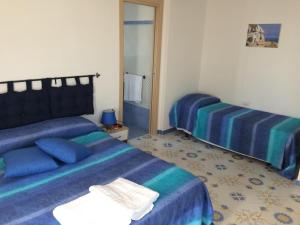 una camera d'albergo con due letti e uno specchio di Il Canto Dei Venti a Montecorice