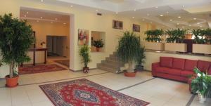 um átrio com um sofá vermelho e vasos de plantas em Hotel Palace Gioia Tauro em Gioia Tauro