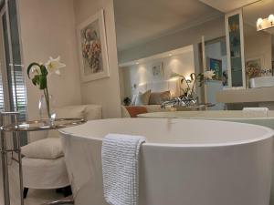 a bathroom with a sink and a living room at Village Square 10 in Plettenberg Bay +6 photos