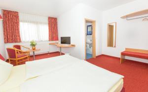 una camera d'albergo con letto e scrivania di Steigerwaldpension a Wiesentheid