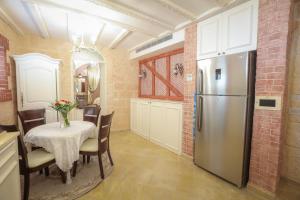 eine Küche mit Tisch und Kühlschrank in der Unterkunft Western Wall Luxury House in Jerusalem