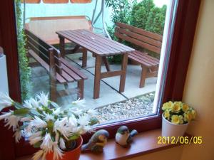 a window with a bench and a table and flowers at Palma Panzio in Fót