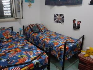 1 Schlafzimmer mit 2 Einzelbetten und einem Bett mit amerikanischer Flagge in der Unterkunft Torre dei Normanni in Marina di Sibari