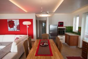 a living room and kitchen with a table and a couch at Exclusive Apartments DEBELI RTIČ in Ankaran