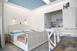 a bedroom with a bed and a table and a kitchen at Exclusive Apartments DEBELI RTIČ in Ankaran