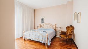 a bedroom with a bed and a chair at Villa Dervio in Dervio