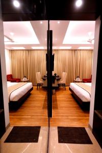 a room with two beds and a table with chairs at Hotel City Pride in New Delhi