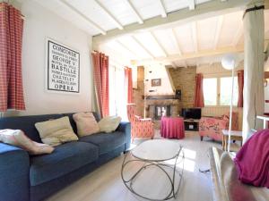 Luxury Pet friendly Chalet in Bi vre near Forest في Bièvre: غرفة معيشة مع أريكة زرقاء وطاولة
