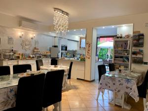 a dining room with tables and chairs and a kitchen at B&B Garda 4U in Desenzano del Garda