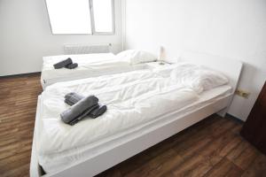 two white beds in a room with wooden floors at Ferienwohnung in Duisburg Monteurwohnung in Duisburg