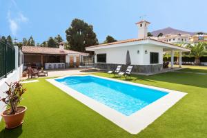 a backyard with a swimming pool and green grass at Finca La Vizcondesa in Icod de los Vinos