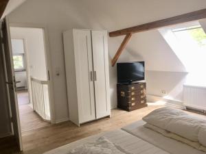 a bedroom with a bed and a flat screen tv at Deichhof von 1843 in Tossens direkt an der Nordsee für 12 Personen in Butjadingen