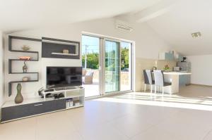 a white living room with a fireplace and a table at Villa Vrh in Krk