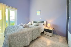 a bedroom with a large bed and a window at Villa Vrh in Krk +29 photos