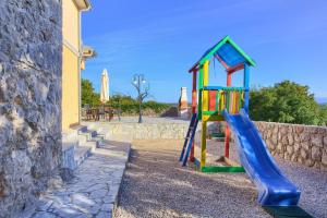 a playground with a slide next to a wall at Villa Vrh in Krk