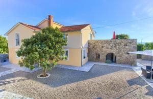 a house with a tree in front of it at Villa Vrh in Krk