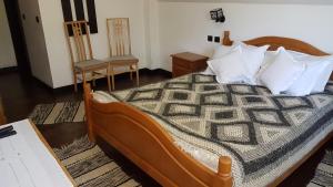 1 Schlafzimmer mit einem Bett und 2 Stühlen in der Unterkunft Pensiunea Maria-Bucovina in Vatra Moldoviţei