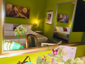 Zimmer mit 2 Betten und einem Spiegel in der Unterkunft AS Hotel Sempione Fiera in San Vittore Olona