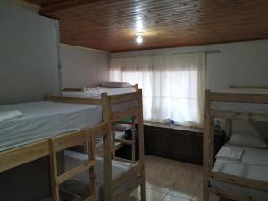 a room with three bunk beds and a window at Iguazu Rey Hostal in Puerto Iguazú