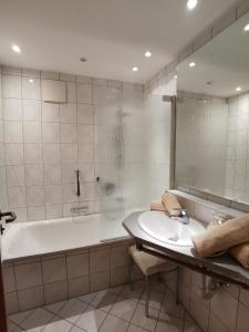 a bathroom with a tub and a sink and a bath tub at Haus Edelweiss in Oberstdorf