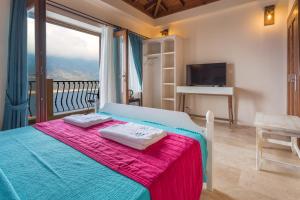 a bedroom with a bed and a balcony with a television at Hillcity Hotel in Kas