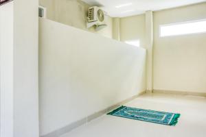 a room with a door and a rug on the floor at RedDoorz @ Plemburan Jakal 2 in Yogyakarta +8 photos