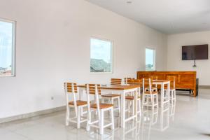 ein Esszimmer mit einem Tisch, Stühlen und einem Klavier in der Unterkunft RedDoorz @ Plemburan Jakal 2 in Yogyakarta