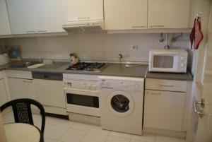 una cucina con lavatrice e forno a microonde di Akisol Vilamoura Hill a Vilamoura