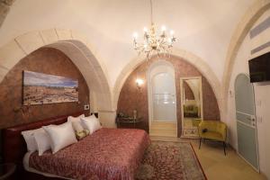ein Schlafzimmer mit einem großen Bett und einem Kronleuchter in der Unterkunft Western Wall Luxury House in Jerusalem