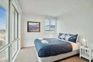 a white bedroom with a bed and a window at Queenie's Lakeview Star in Lake Tekapo