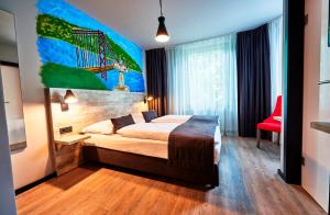 um quarto com uma cama e um quadro na parede em Urban Home Hotel em Hamburgo