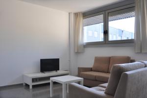 a living room with a couch and a tv at Residencia Universitaria Campus de Montilivi in Girona