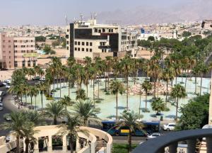 vistas a una ciudad con palmeras y edificios en Dweik Hotel 2, en Áqaba