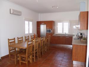 uma cozinha com uma mesa de madeira e cadeiras de madeira em casa Bandoleros em Arenas