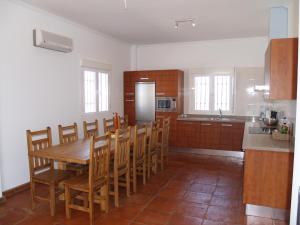 a kitchen with a wooden table and wooden chairs at casa Bandoleros in Arenas