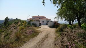 un camino de tierra que conduce a una casa en una colina en casa Bandoleros, en Arenas