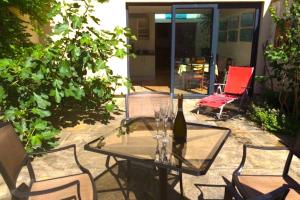 a glass table with a bottle of wine on a patio at Lauras Townhouse Apartments Thomas Street Townhouse in Bath