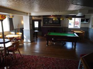 a pub with a pool table in the middle of a room at Ferns Hotel/Palms Leisure in Bridlington