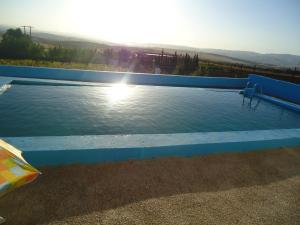 a large swimming pool with the sun in the background at Tahla Garden in Tahla