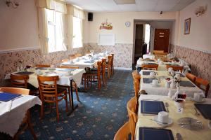 a room filled with tables and chairs with white tables at Tobermory Hotel in Blackpool