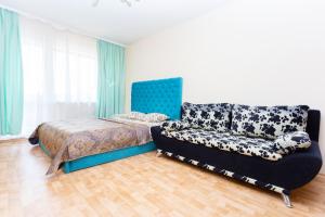 ein Schlafzimmer mit einem Sofa, einem Bett und einem Stuhl in der Unterkunft Apartment Zhukovskogo 5/2 in Minsk