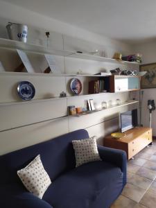 a living room with a blue couch and shelves at Lovely Grado in Grado