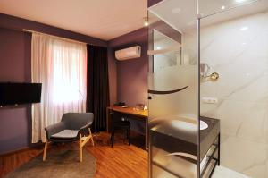 a hotel room with a desk and a shower at Elle Boutique Hotel in Tbilisi City
