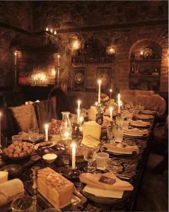 a long table with candles and plates of food at Cheltikov Hotel in Kars